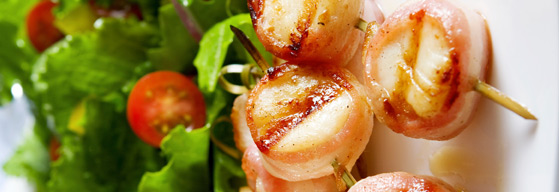 seafood on sticks with a side of green salad 